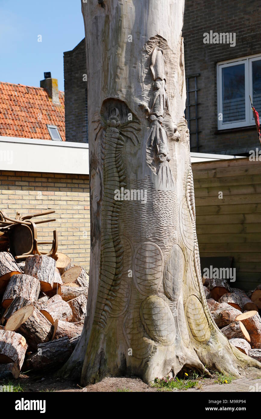 a tree trunk in which animals are cut out Stock Photo - Alamy