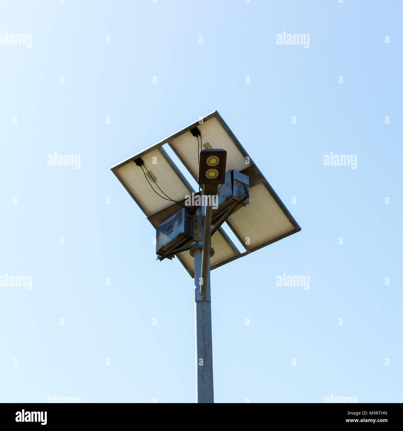 Road lamp with small solar panel on blue sky background. Stock Photo