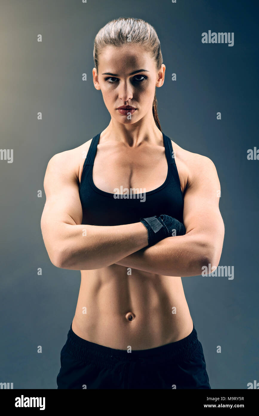 Muscular sporty lady posing with arms crossed Stock Photo - Alamy