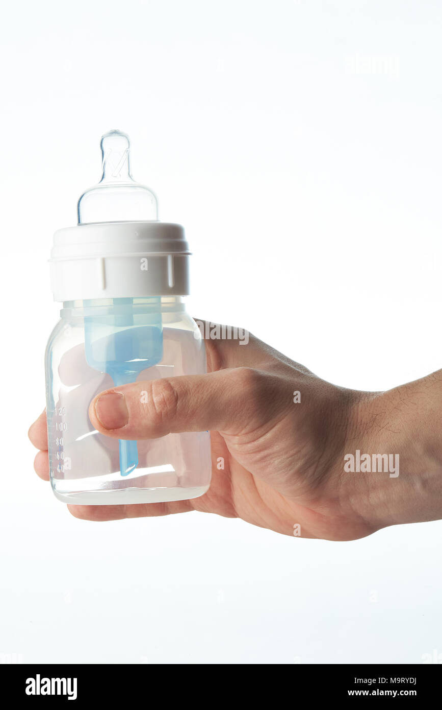 Empty plastic baby feeding bottle in hand isolated on white background Stock Photo