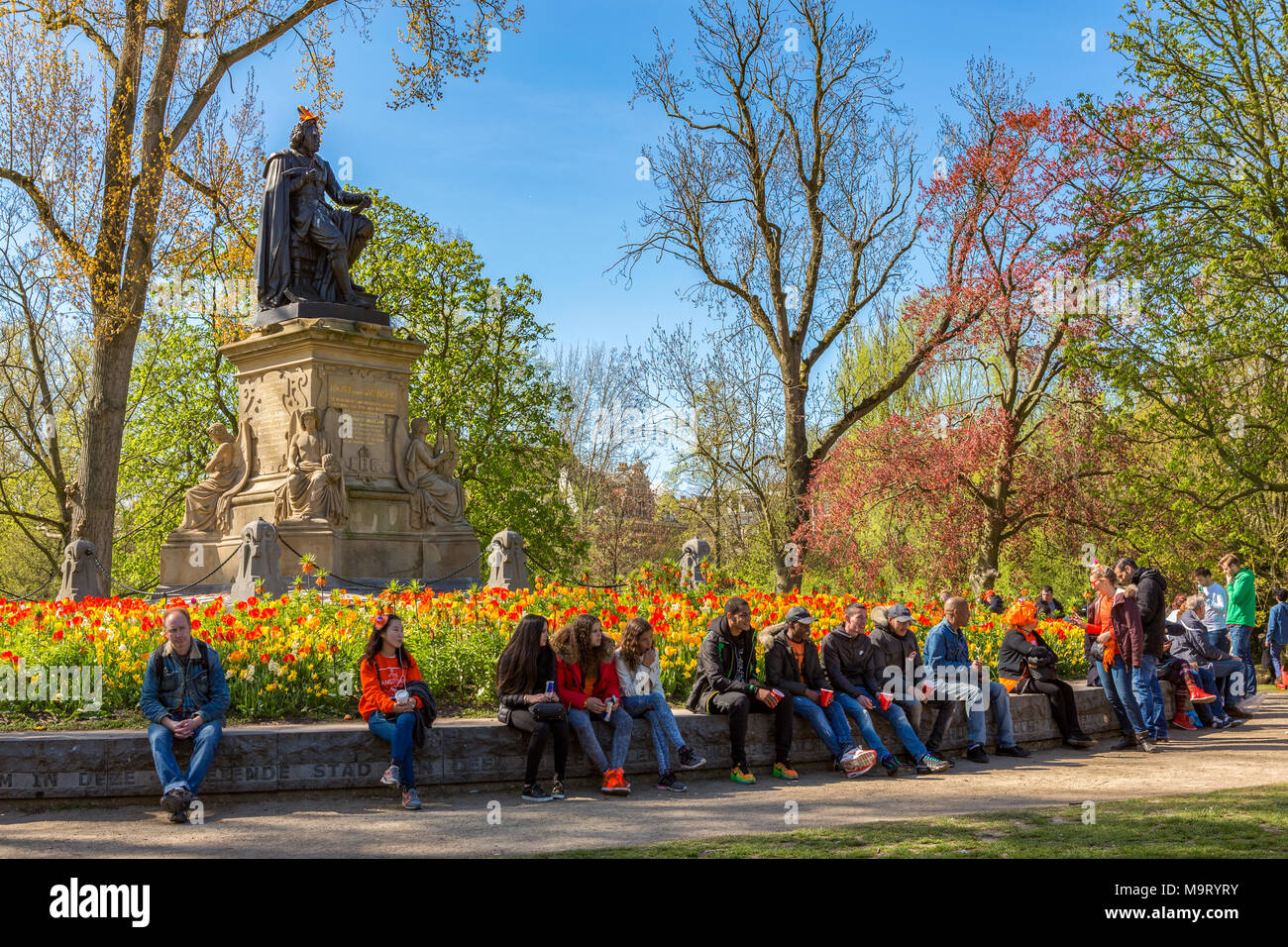 People relaxing at the Statue of Joost van den Vondel in the Vondelpark in Amsterdam the Netherlands Stock Photo
