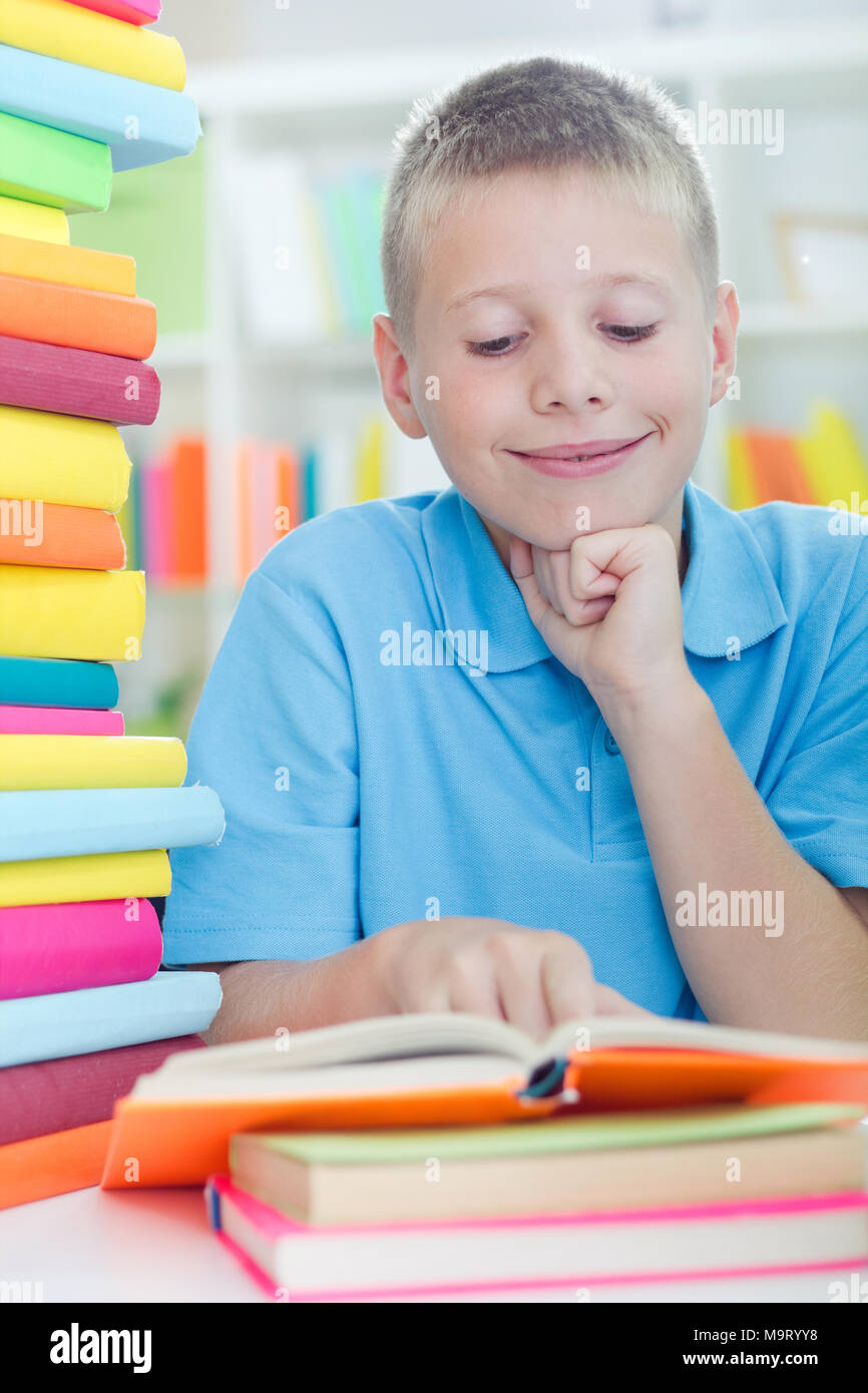 young boy learns from books at home Stock Photo