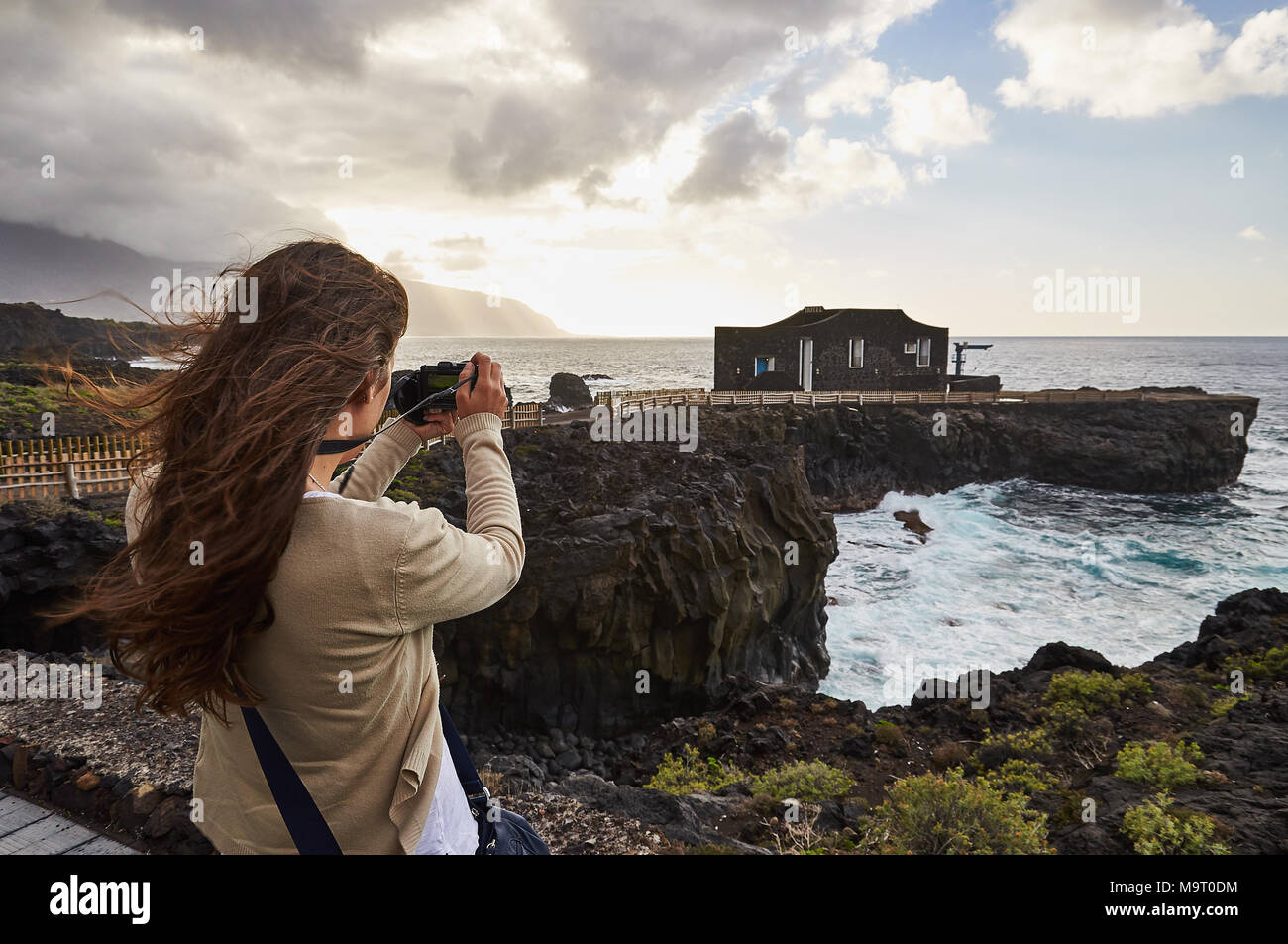 Girl photographing a panoramic view of Punta Grande Hotel, the smallest hotel in the world, at El Hierro island (Canary Islands, Spain) Stock Photo