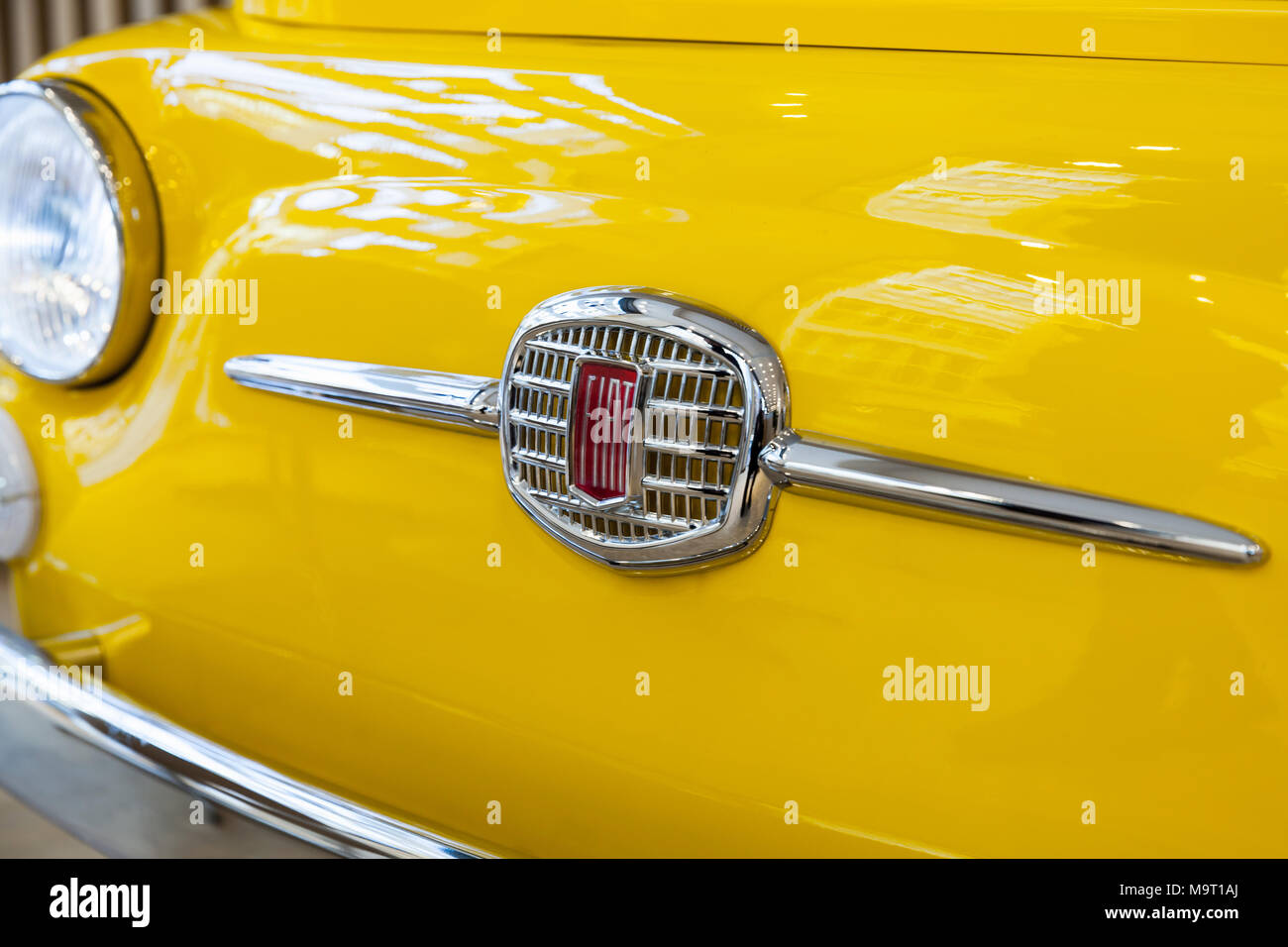 Milan, Italy - January 19, 2018: FIAT Group company logo on yellow Fiat 500 car hood, close up photo with selective focus Stock Photo