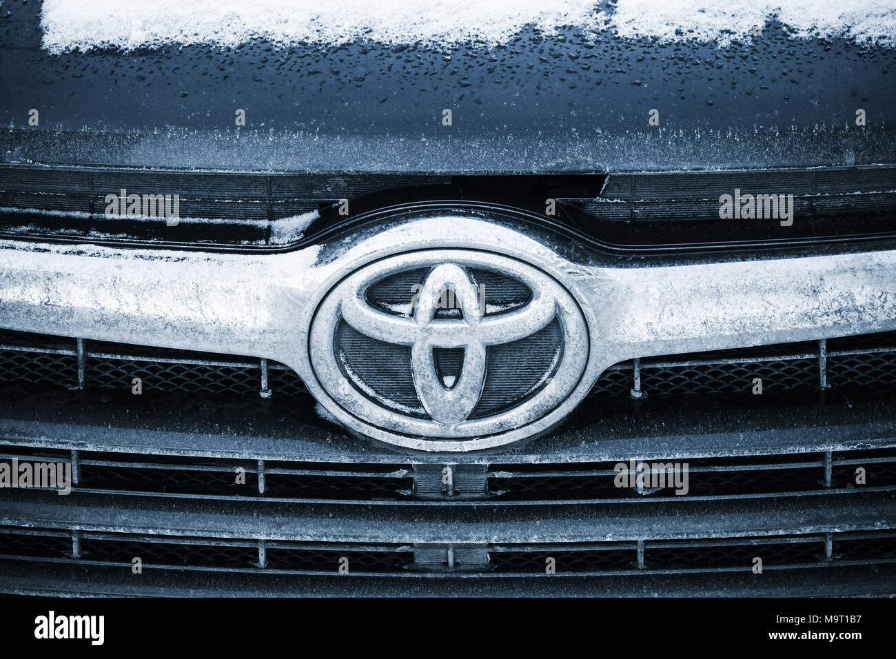 Saint-Petersburg, Russia - February 27, 2018: Toyota Motor Corporation company logo on front grille of black Highlander car, close-up photo Stock Photo
