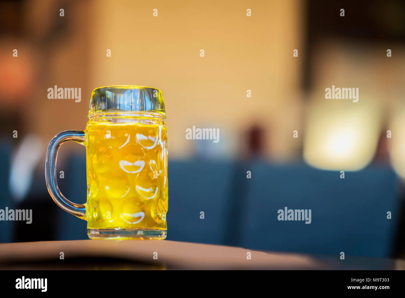 Glass mug of golden light beer in bar, in pub close up. Real scene. Beer culture, Craft brewery