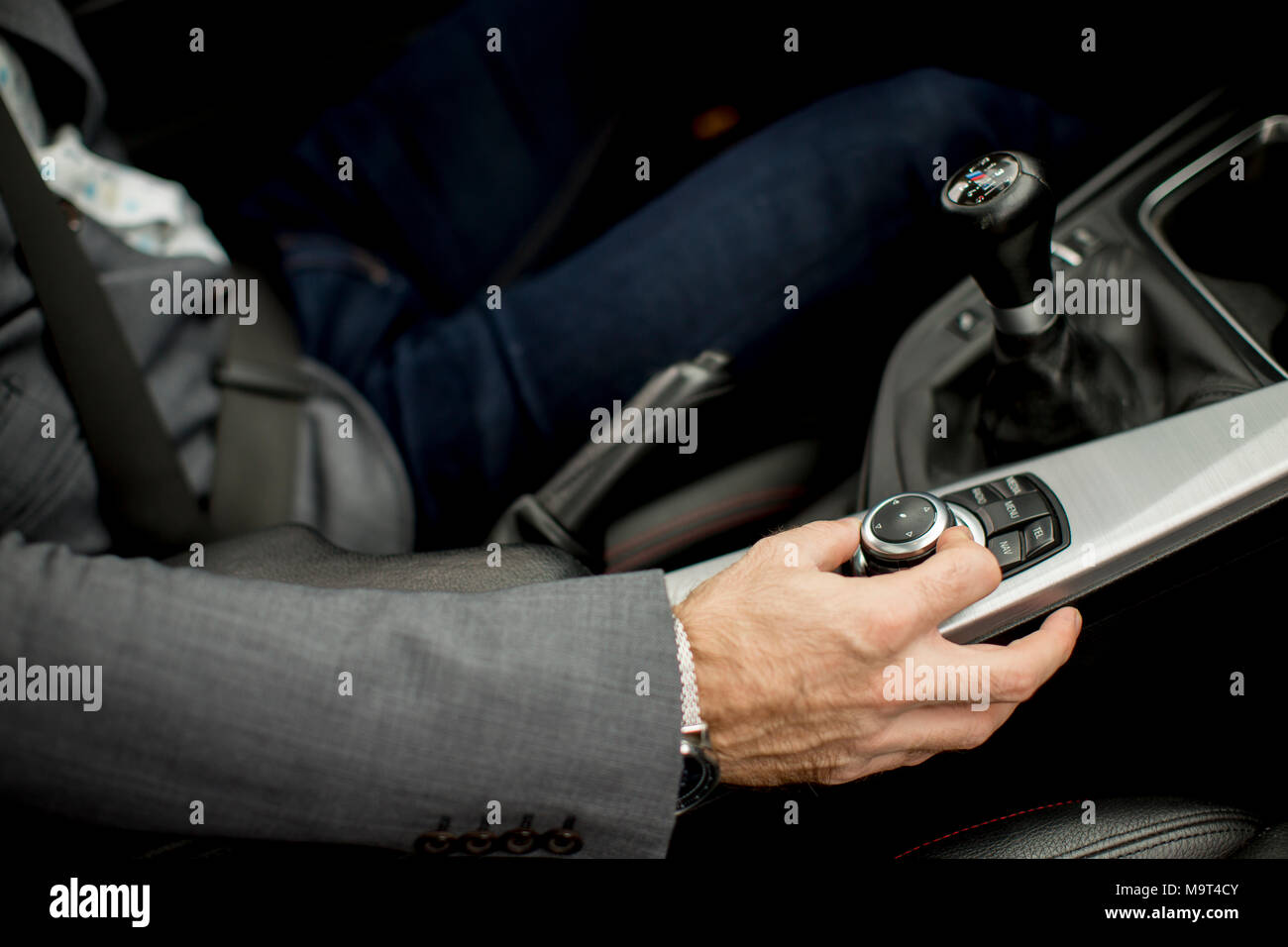 View at young handsome man changing gears during driving of modern car