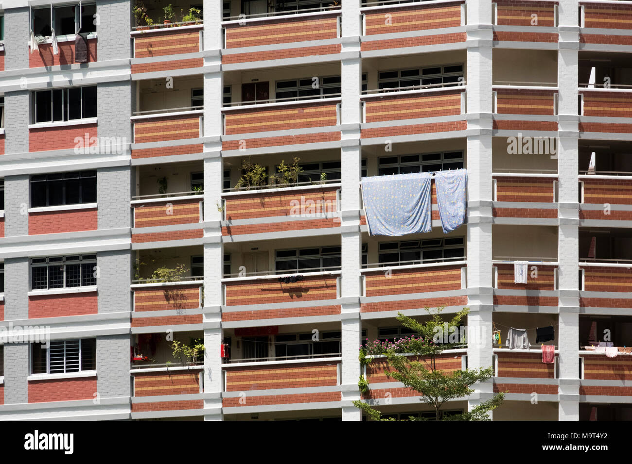 high-rise residential apartment building in Singapore with sheets hanging over balcony Stock Photo