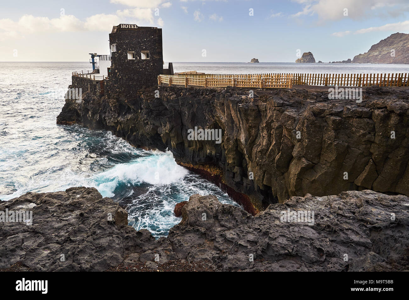Punta Grande Hotel, the smallest hotel in the world, and Roques de Salmor islets in the background (El Hierro, Canary Islands, Atlantic sea, Spain) Stock Photo
