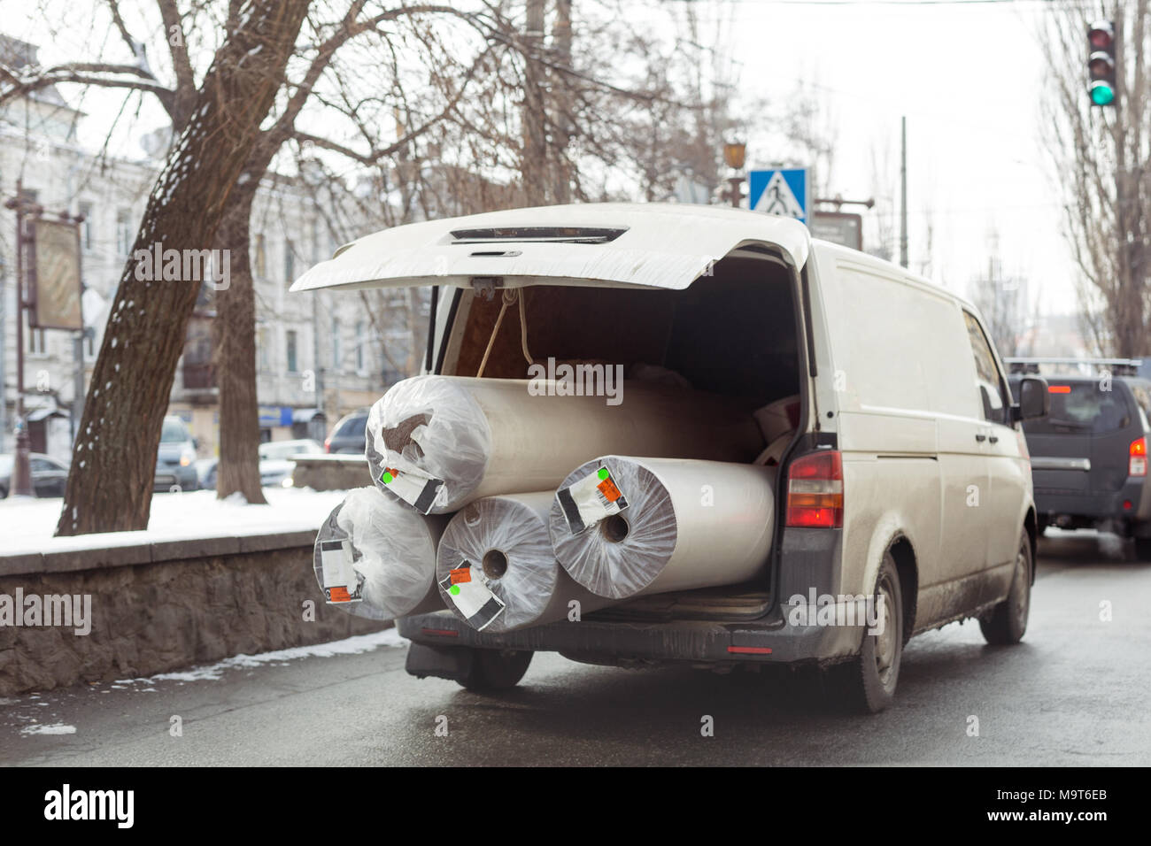 Carpet delivery van with open trunk. Large bulky cargo transportation