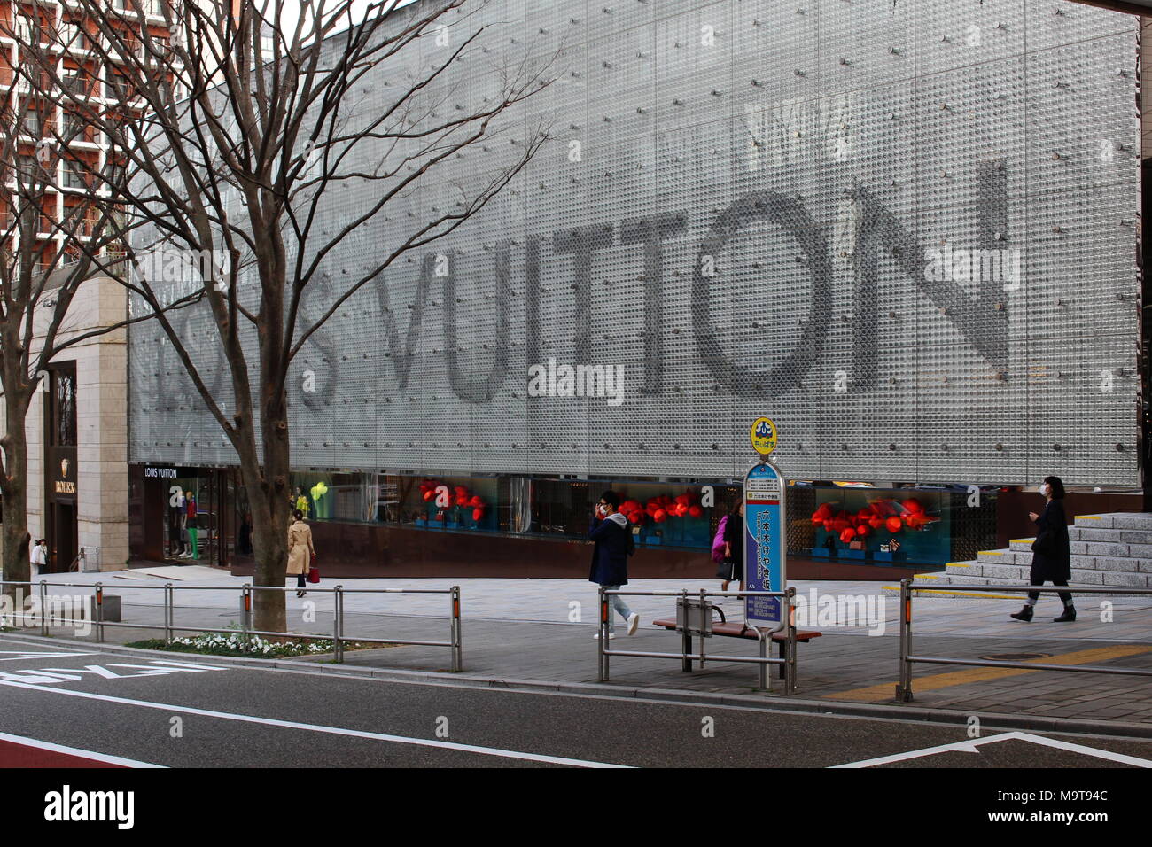 People walk past a large Louis Vuitton store in Tokyo&#39;s Roppongi Hills area Stock Photo ...