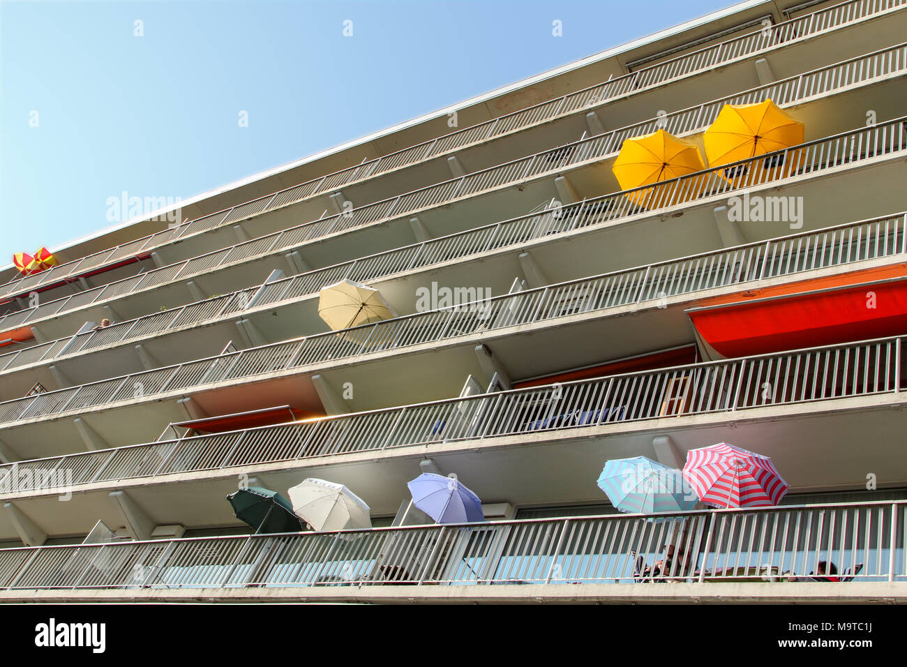 Colorful umbrellas on balconies of an apartment complex at the Delfland square in Amsterdam the Netherlands. Stock Photo