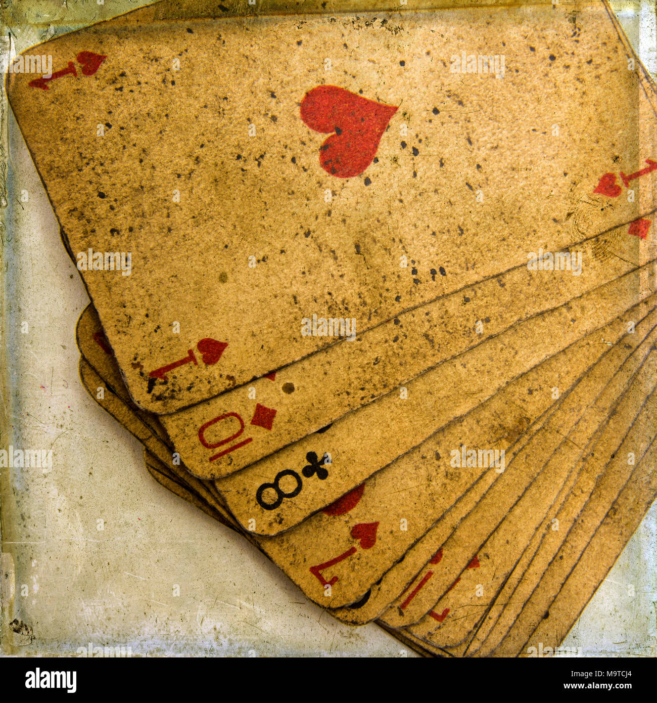 Closeup shot of worn-out playing cards put in a pile - perfect for background Stock Photo