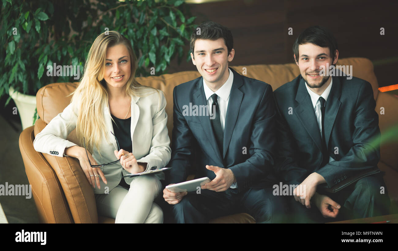 business team in a work break, sitting on the couch in the lobby Stock