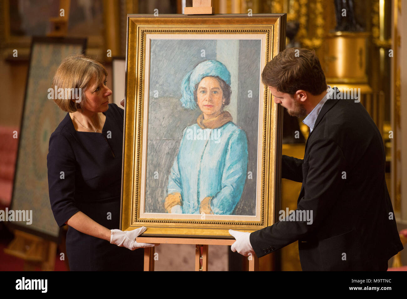 Royal Collection staff adjust (front row, left to right) an oil sketch 'HM the Queen, 1972-73' by Michael Noakes during the press preview of the Prince and Patron exhibition at Buckingham Palace, London, which will mark the 70th birthday of the Prince of Wales this year. Stock Photo