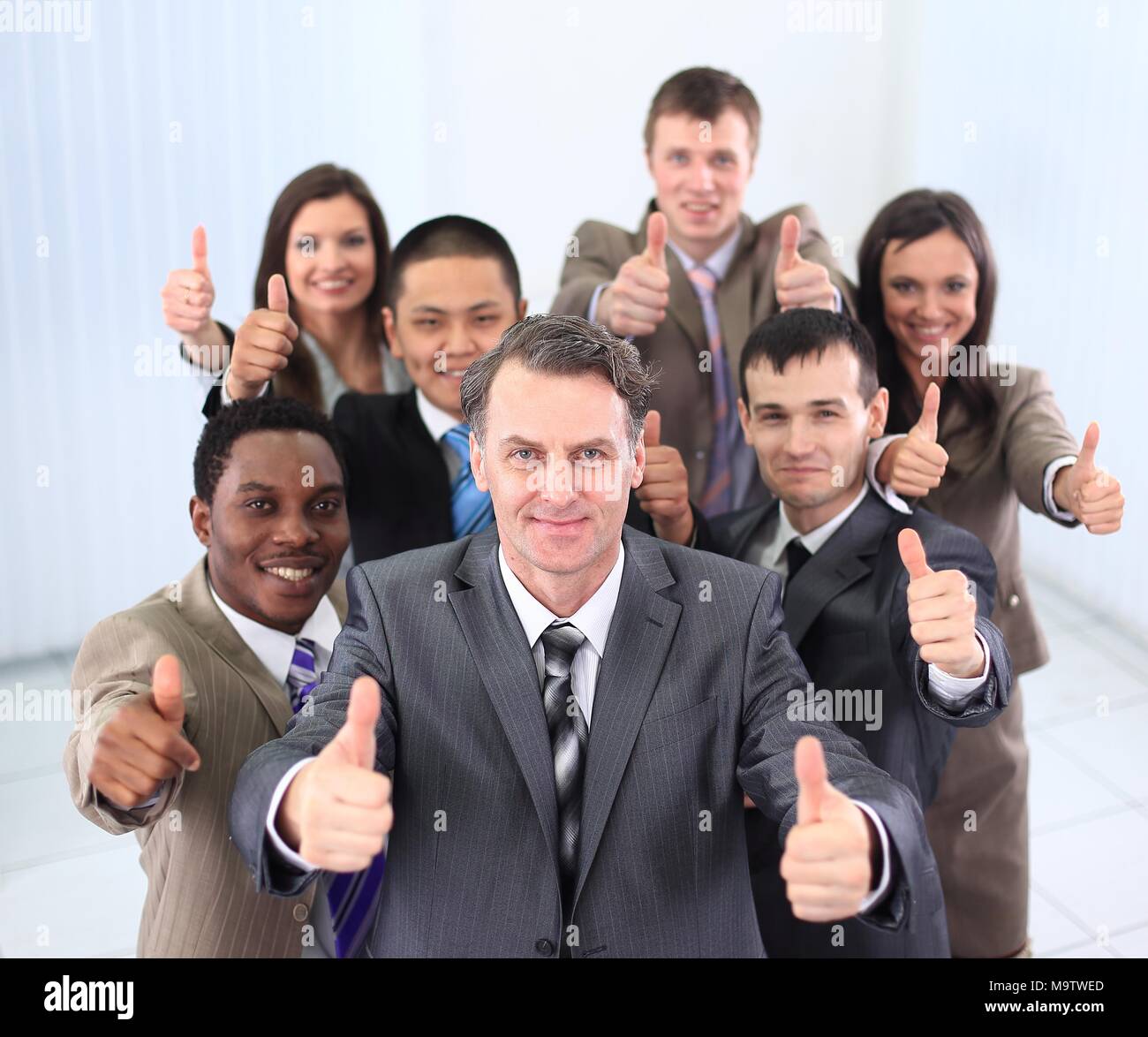 happy business team holding thumbs up Stock Photo - Alamy