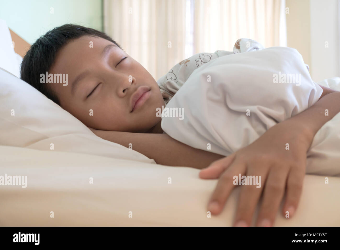 Cute boy sleeping on bed covered with blanket Stock Photo Alamy