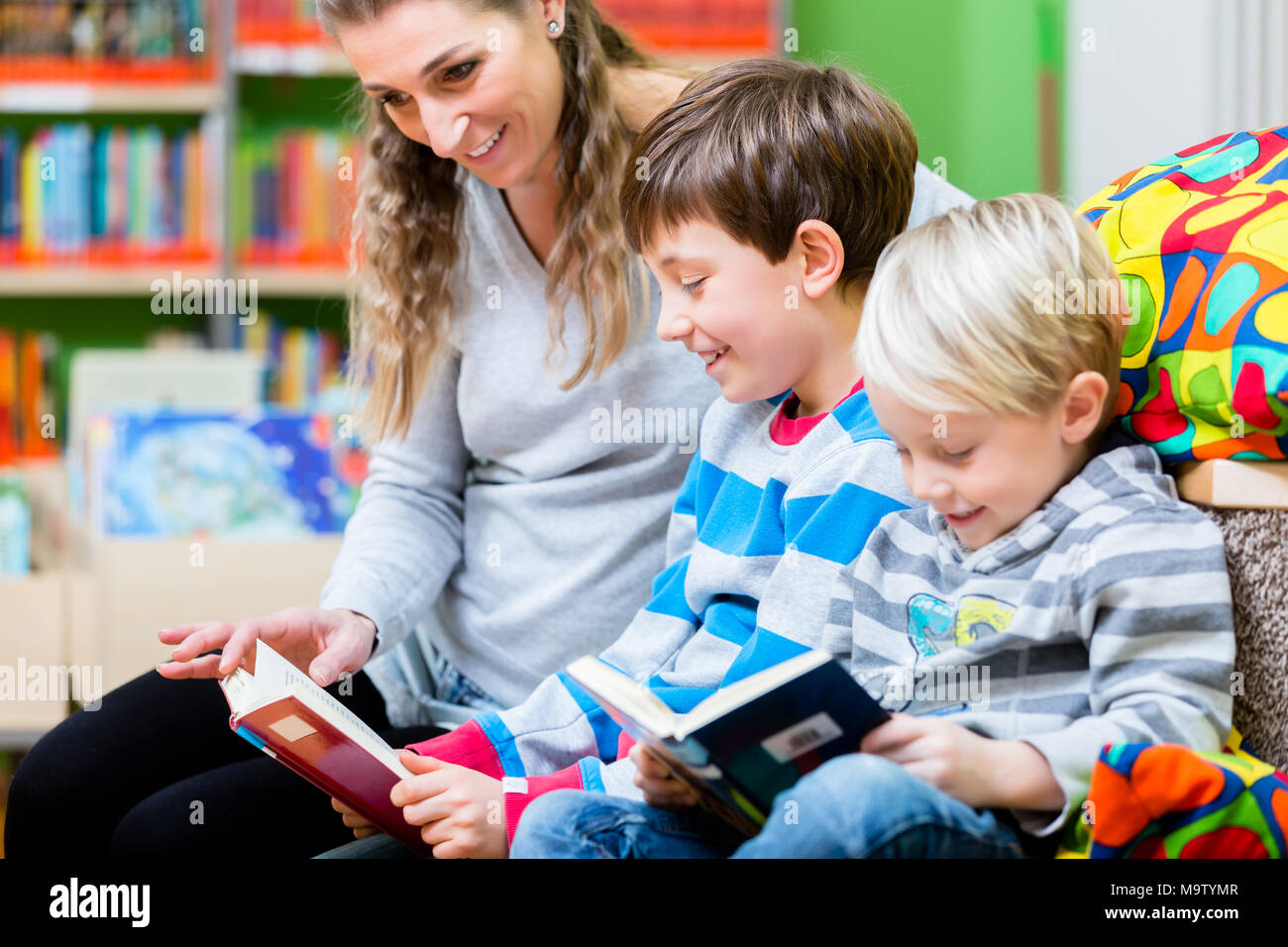 Mom with her kids for the first time in the library Stock Photo