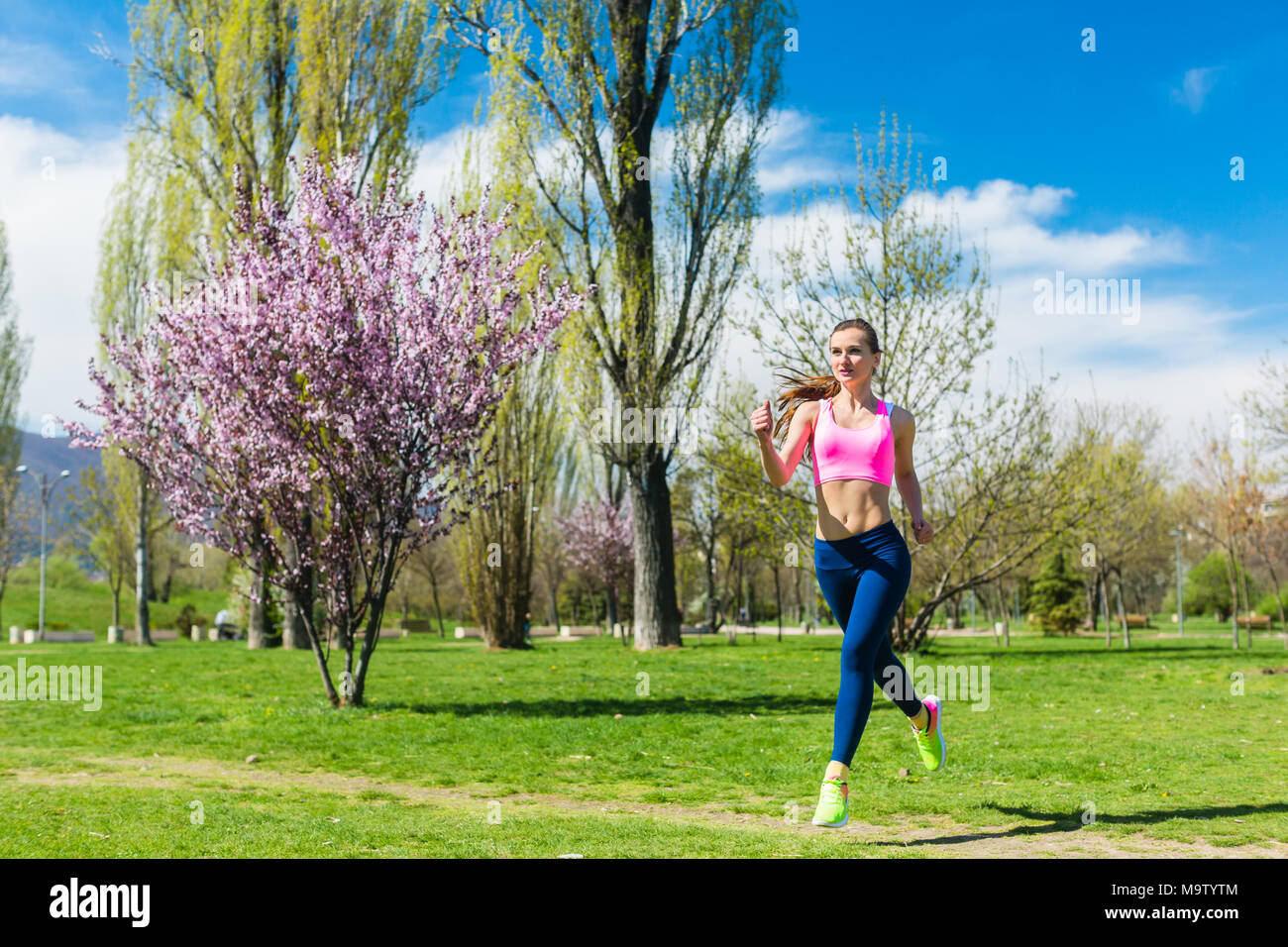 Young running woman in fitness outfit hi-res stock photography and