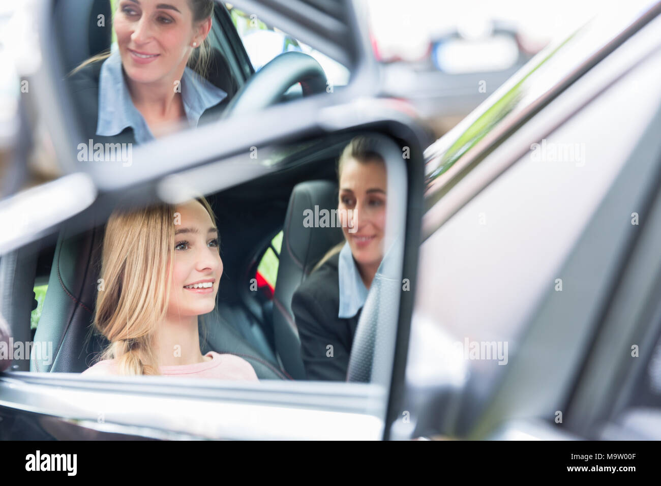 Student in driving school at the wheel of a car with her instructor Stock Photo