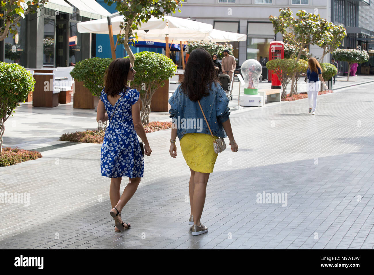 Rear view of female tourists walking in DUbai Stock Photo