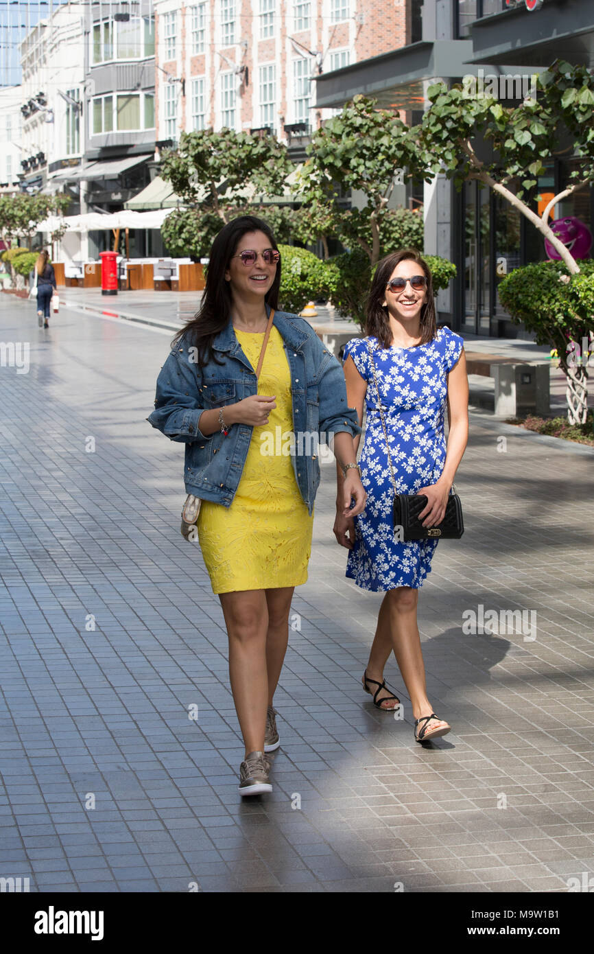 Two happy female tourists walking in dubai Stock Photo