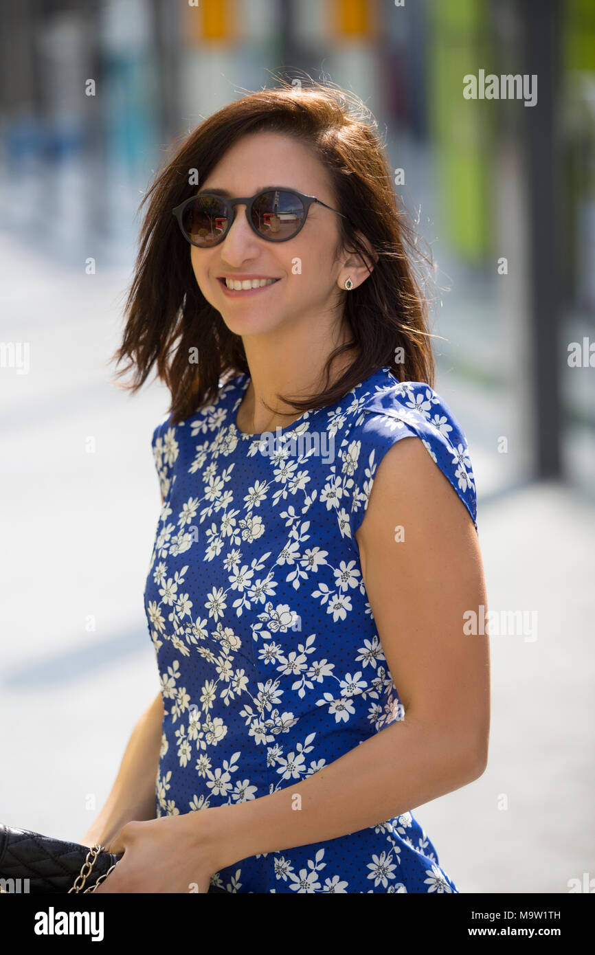 Beautiful woman wearing sunglasses looking away smiling outdoors Stock Photo