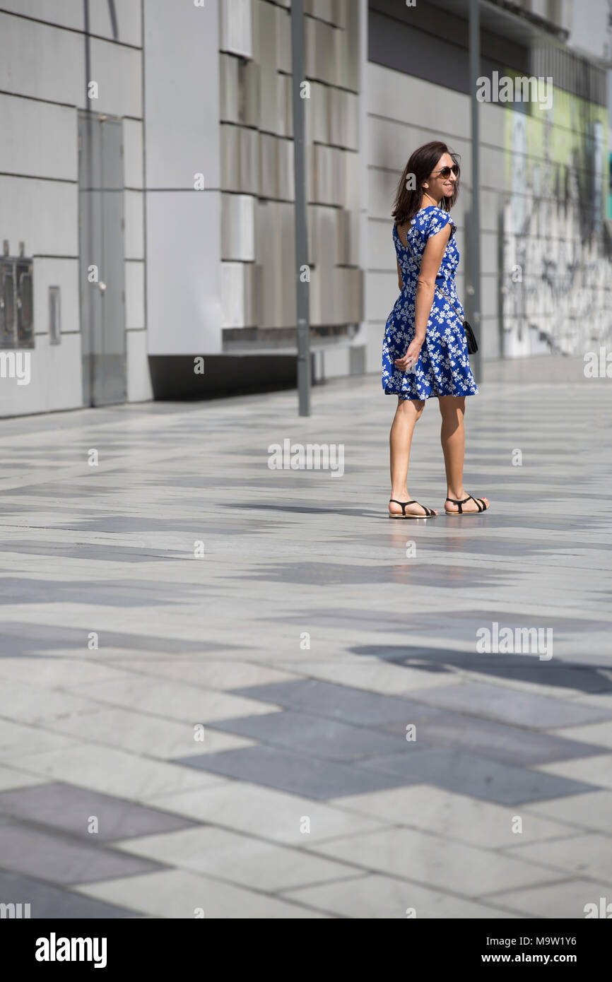 Rear view of a happy woman walking away on the street Stock Photo - Alamy