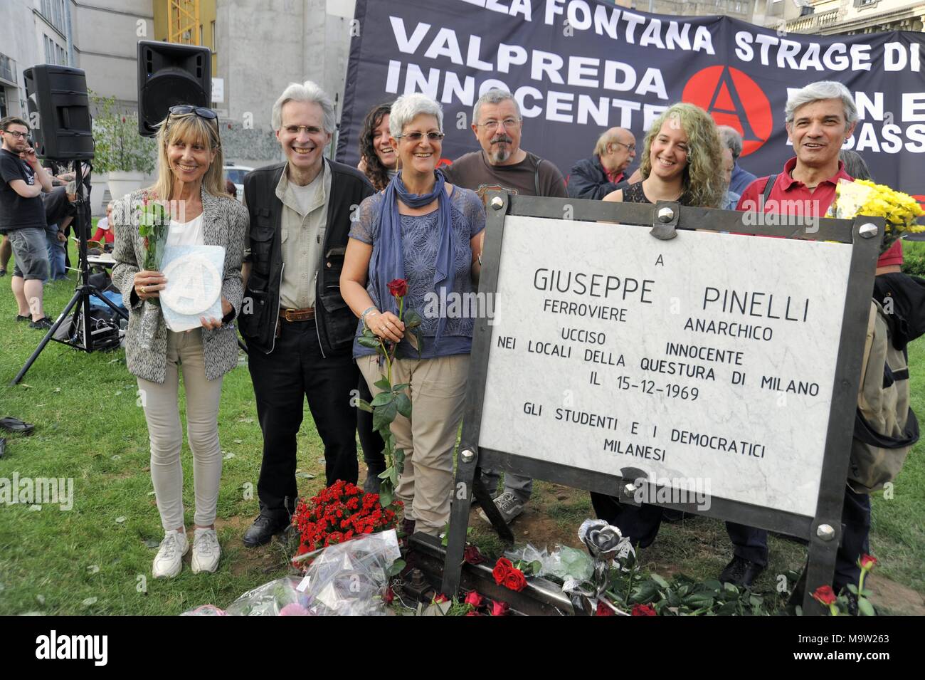 -Milan, 22 May 2016 - Placement in Piazza Fontana, the site of the terrorist attack on the Agricultural Bank in December 1969, the plaque dedicated to the anarchist Pinelli, who was unjustly accused, to replace the old one, worn out by time and vandalism; in the photo from the left Silvia, daughter of Pinelli, Mauro De Cortes, historical spokesman for the Anarchist Circle Ponte della Ghisolfa, and Claudia, the other daughter of Pinelli Stock Photo