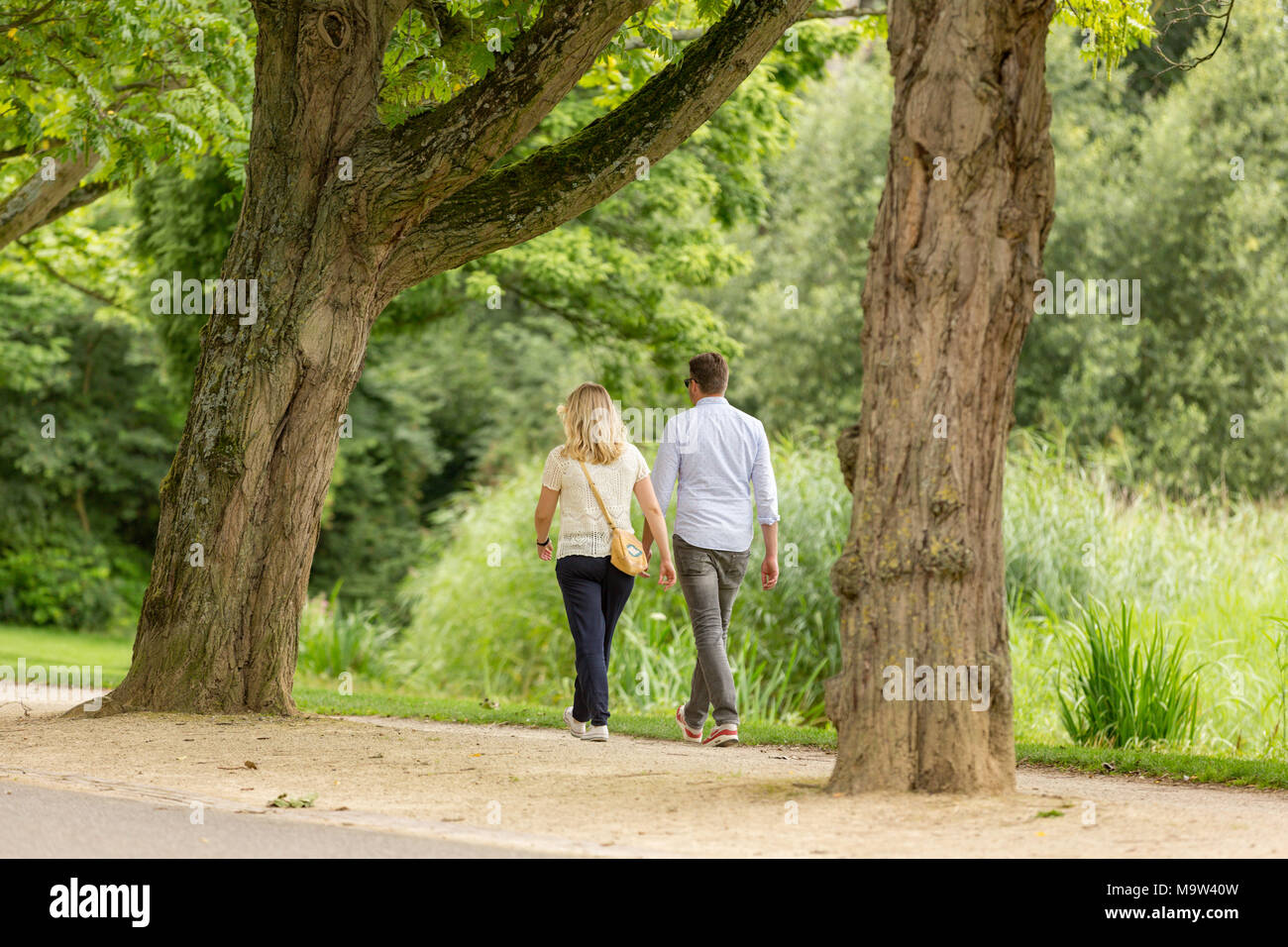 A man and woman walking through the Amsterdam Vondelpark in the Netherlands. Stock Photo