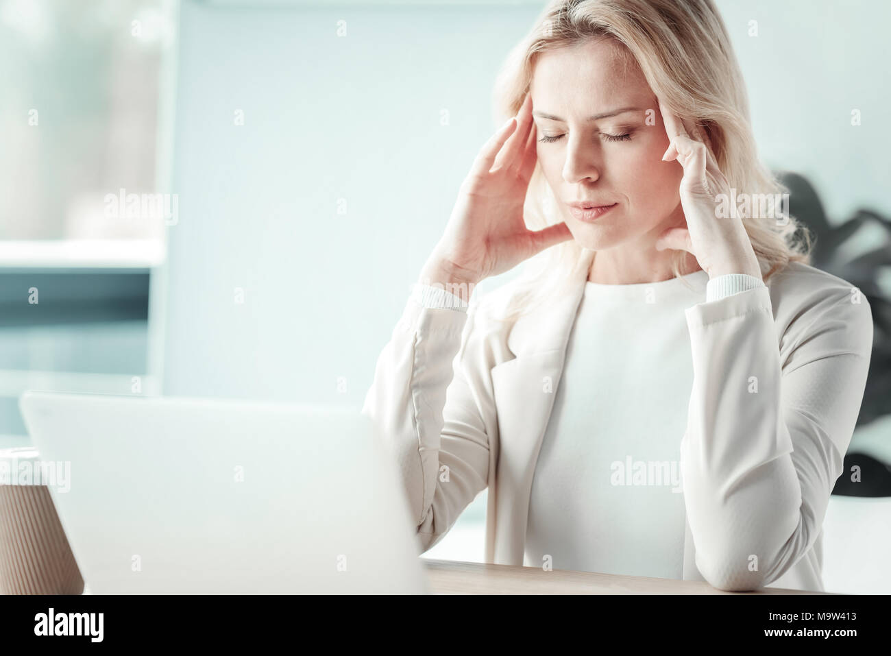 Tired female person massaging temples Stock Photo - Alamy