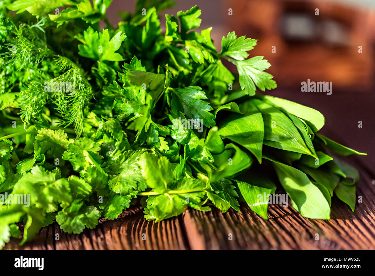 Fresh green cooking herbs on wooden background Stock Photo