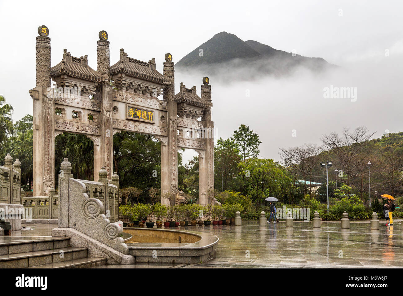 Po Lin Monastery Gate with the mist obscuring the mountain beyond. Located at Ngong Ping, Lantau Island, one of the Hong Kong Islands. Stock Photo