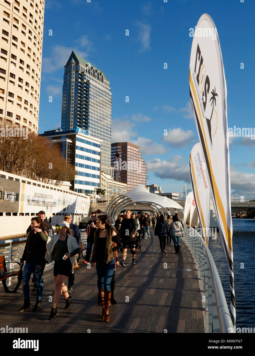 Visitors walk the Tampa Riverwalk over the Hillsborough River during the 2017 College Football Playoff celebrations in Tampa, Florida. Stock Photo