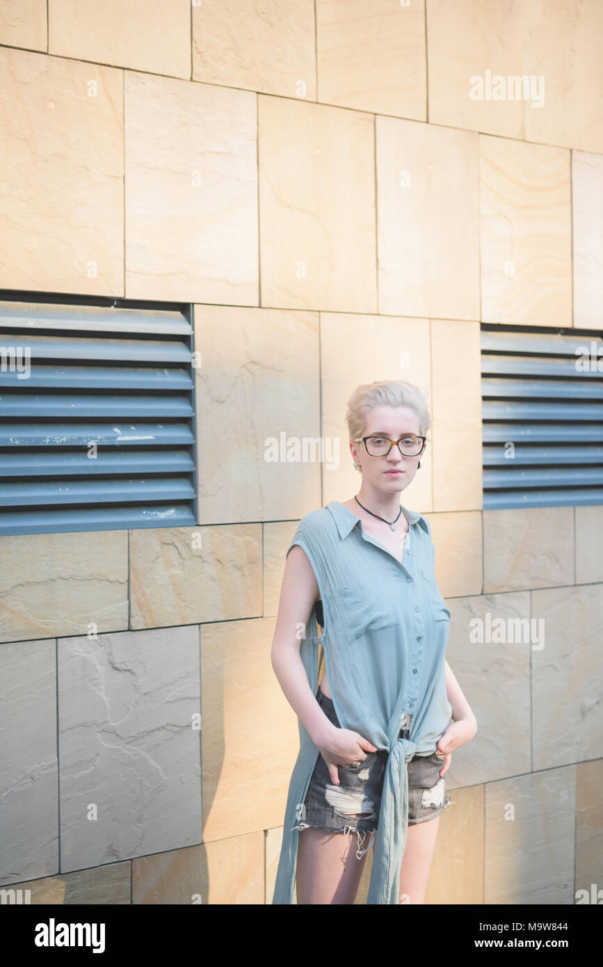 young woman outdoor posing leaning wall looking camera serious - pensive, thoughtful, customer concept Stock Photo