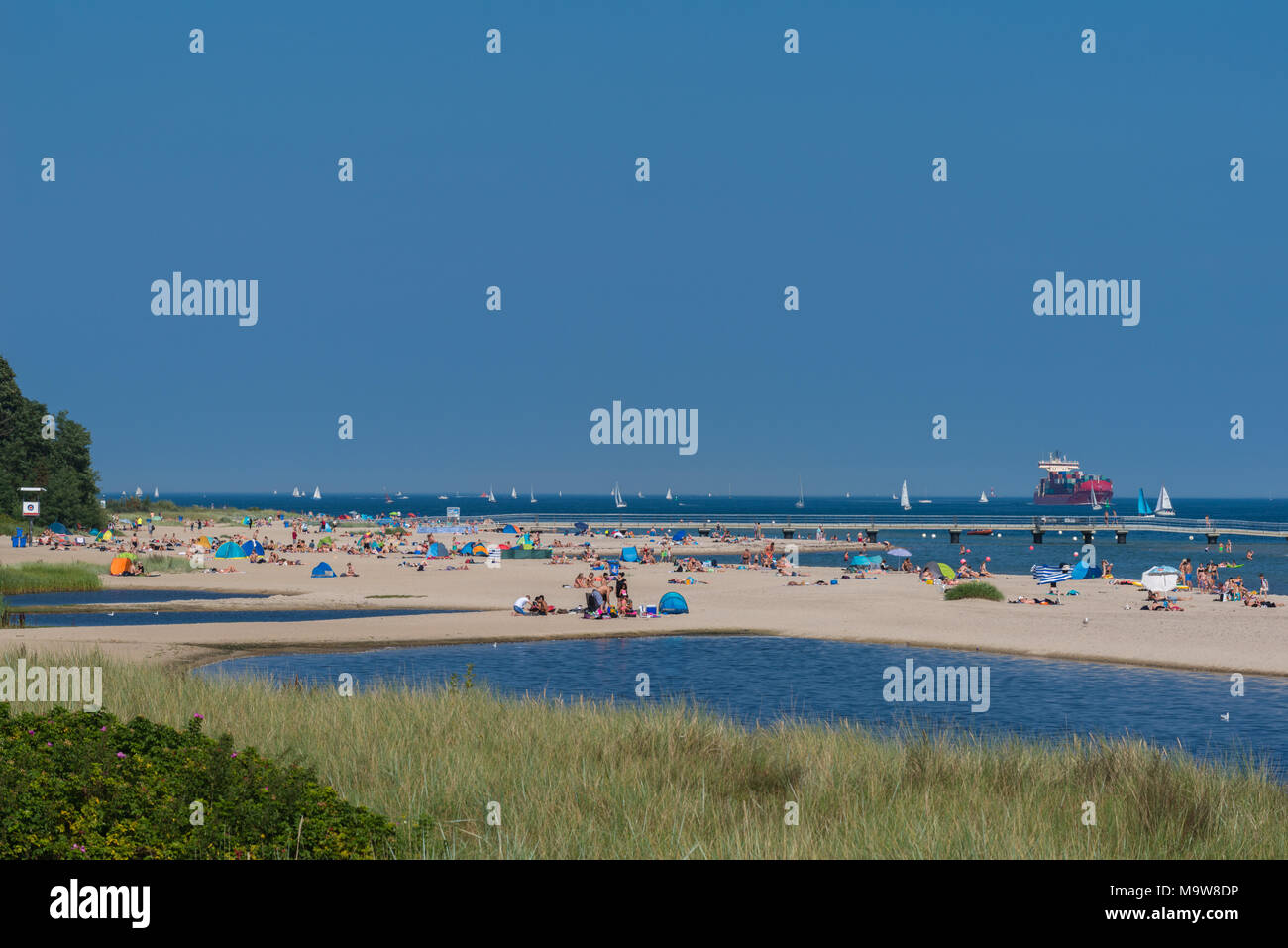 Summertime at the Kiel Fjord. People having fun sunbathing on