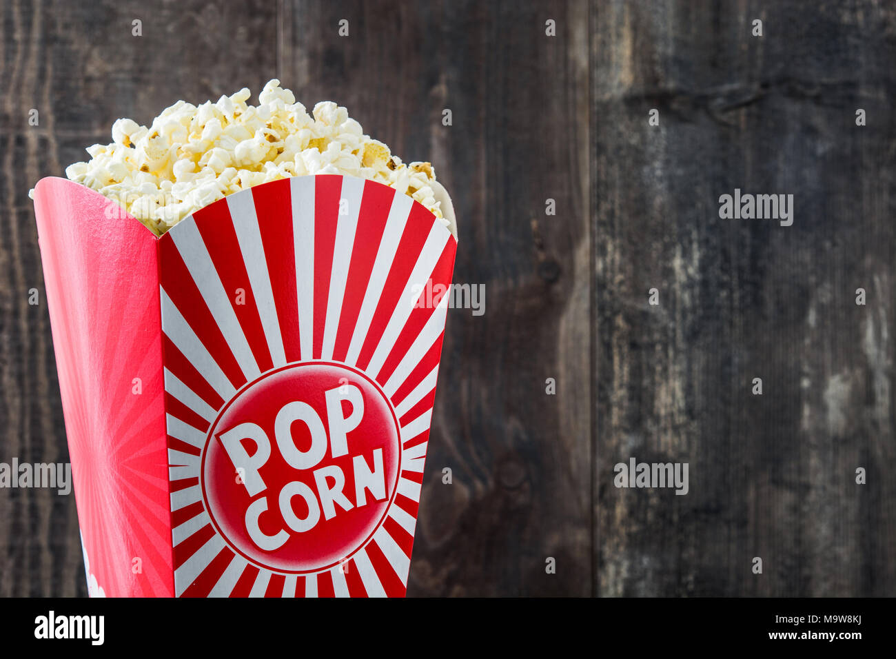 https://c8.alamy.com/comp/M9W8KJ/popcorn-inside-the-packaging-striped-on-wooden-table-background-M9W8KJ.jpg