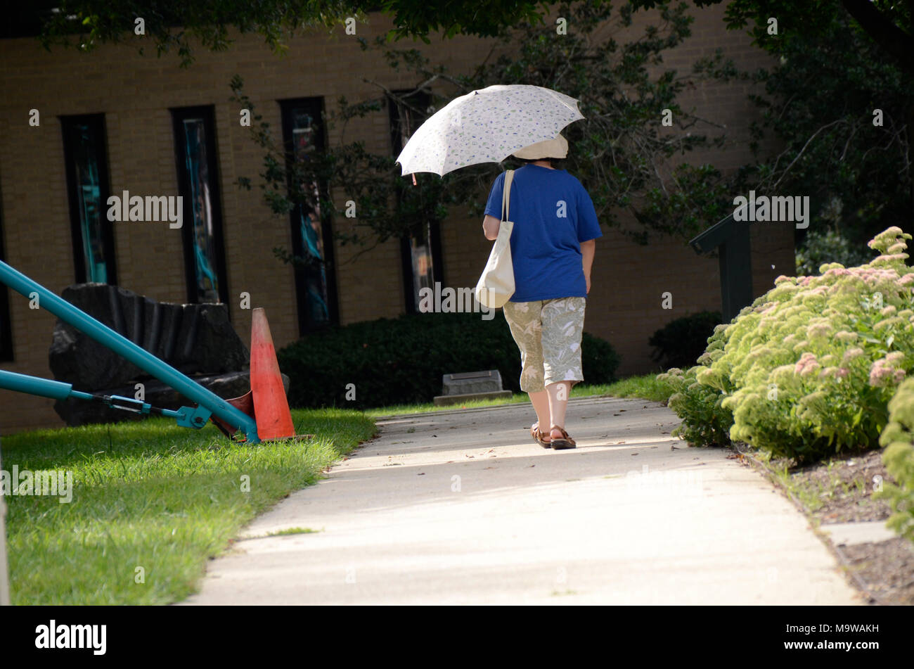 Woman walking with an umbrella hi-res stock photography and images - Alamy