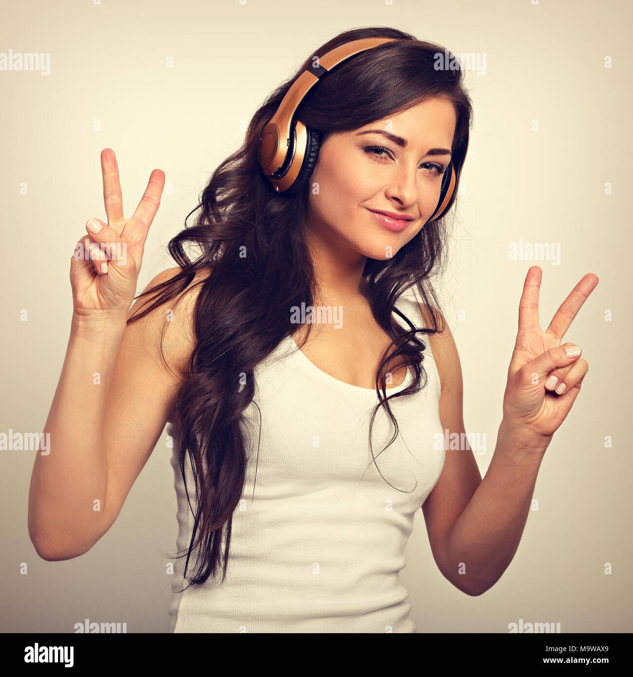 Beautiful happy long hair young woman in casual clothing listening the ...