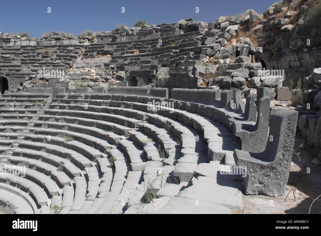 A view of the Roman theatre at Umm Qais. The back row of the seating is made up of high-backed stone basalt seats destined for the elite of the city. Stock Photo