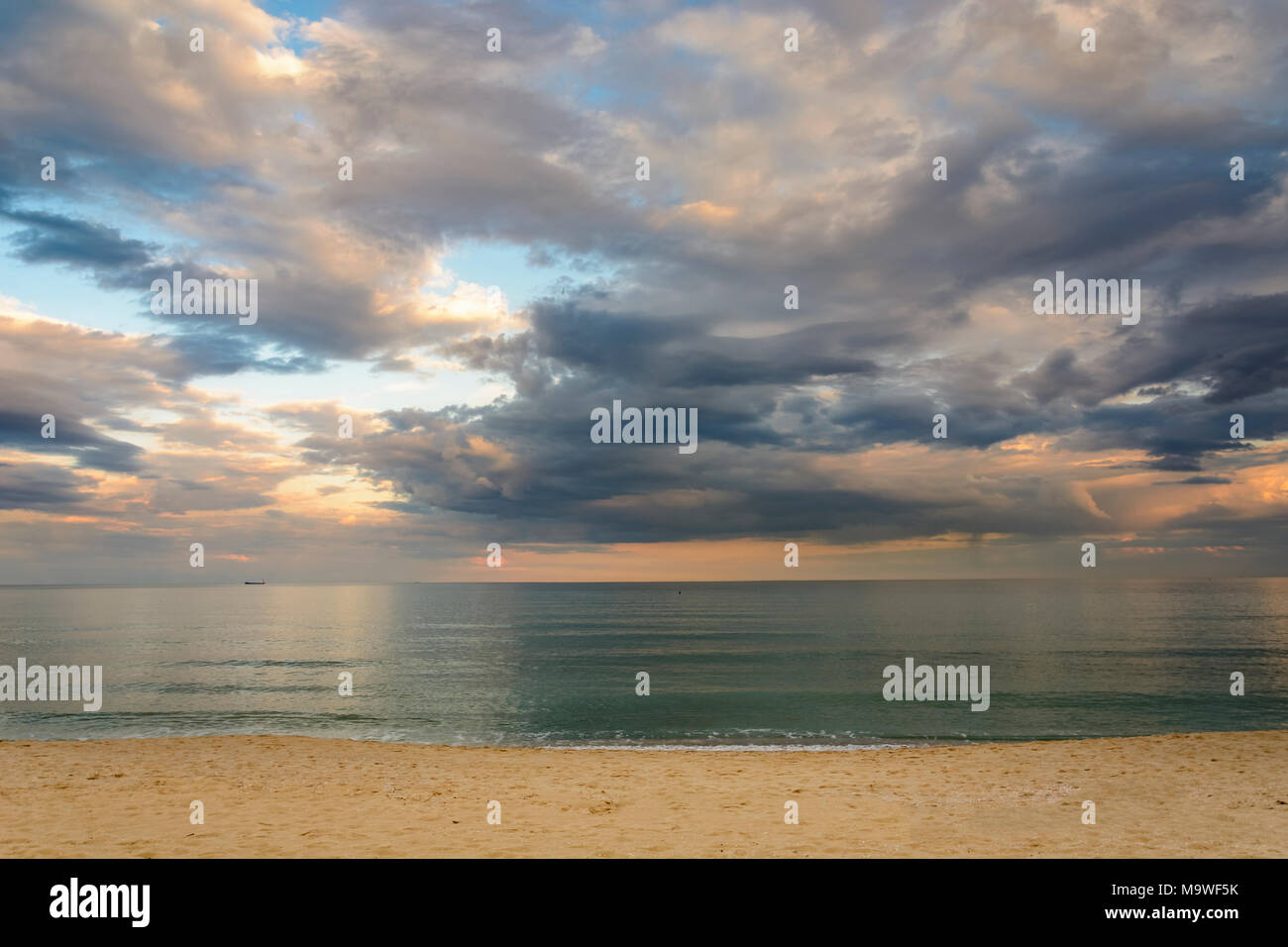 Beach at sunset, Dramatic clouds over the sea Stock Photo - Alamy
