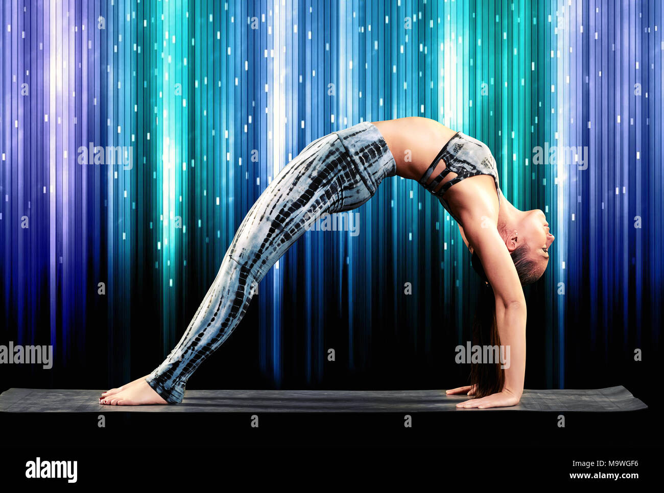 Yoga, young beautiful woman yoga instructor doing Wheel Pose with one leg  lifted straight up (Eka Pada Chakrasana) exercise isolated on white  background. - Album alb8403923