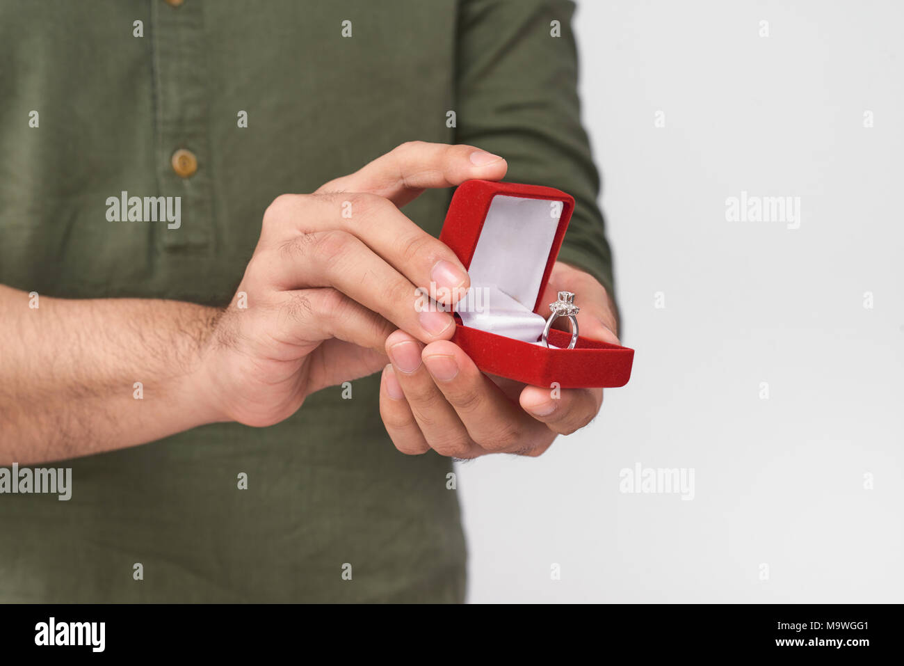 Close up of male hands holding wedding ring and gift box. Stock Photo