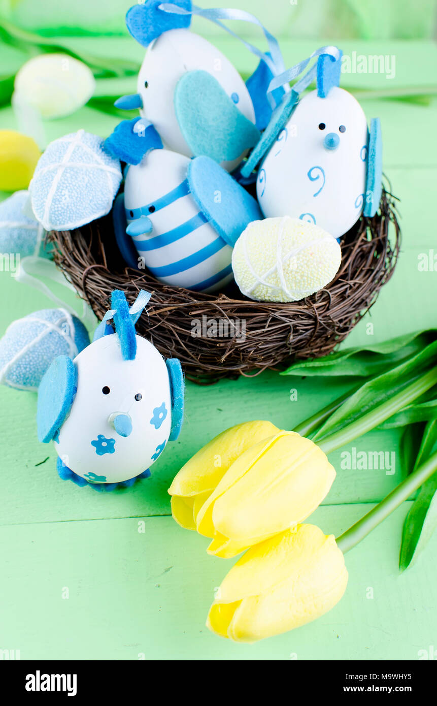 Decorative eggs toys in the nest and tulips for Easter on thelight ...