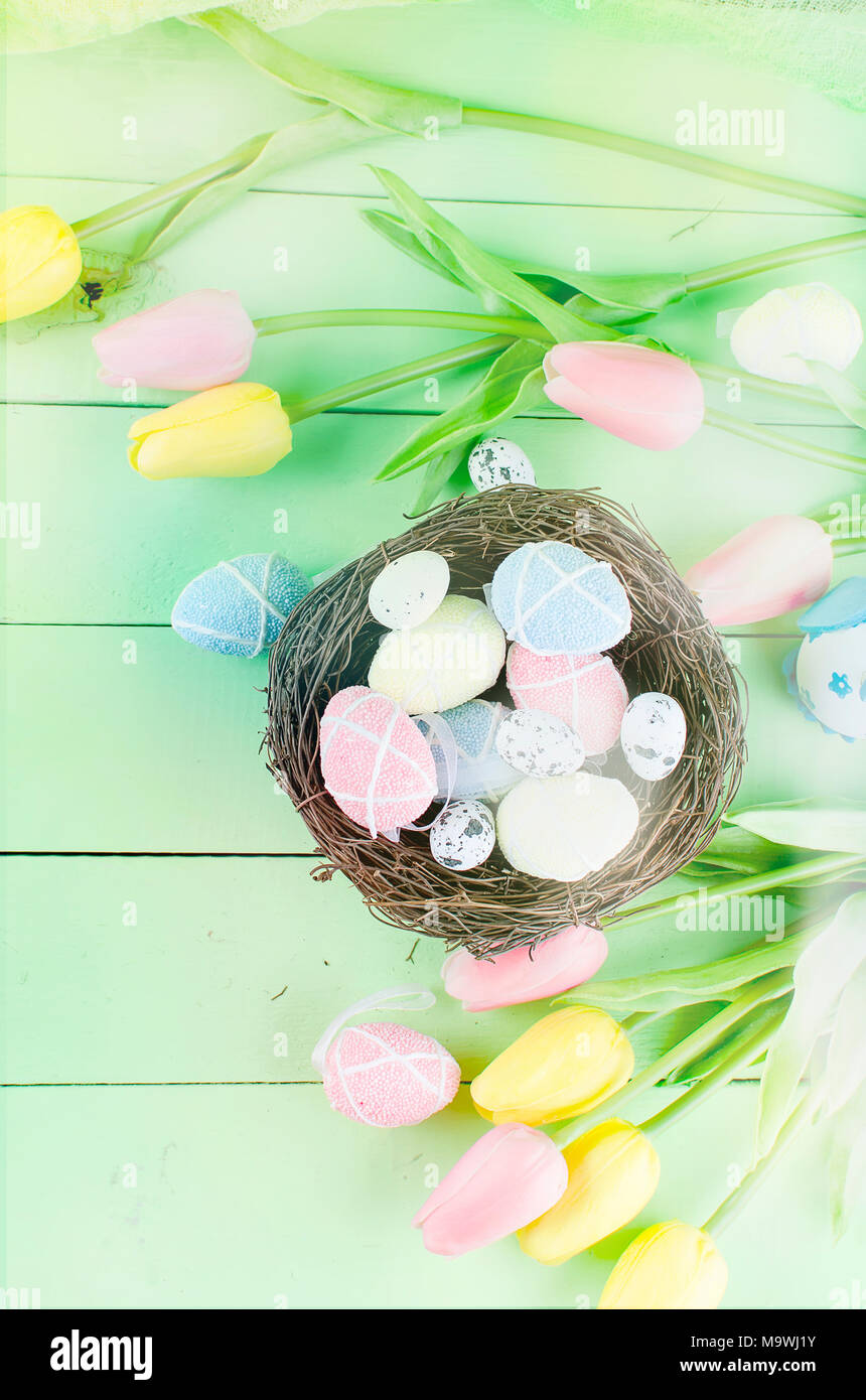 Decorative eggs toys in the nest and tulips for Easter on thelight ...