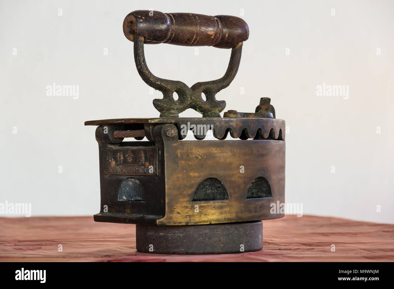 The back of an antique charcoal box iron with its own stand. Stock Photo