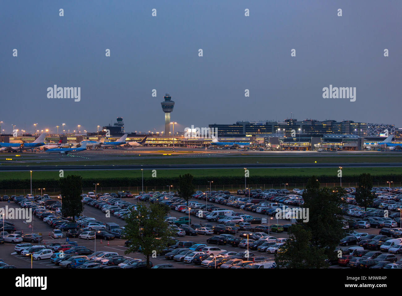 Start tower and airplanes in the evening on Schiphol airport in the Netherlands. Stock Photo