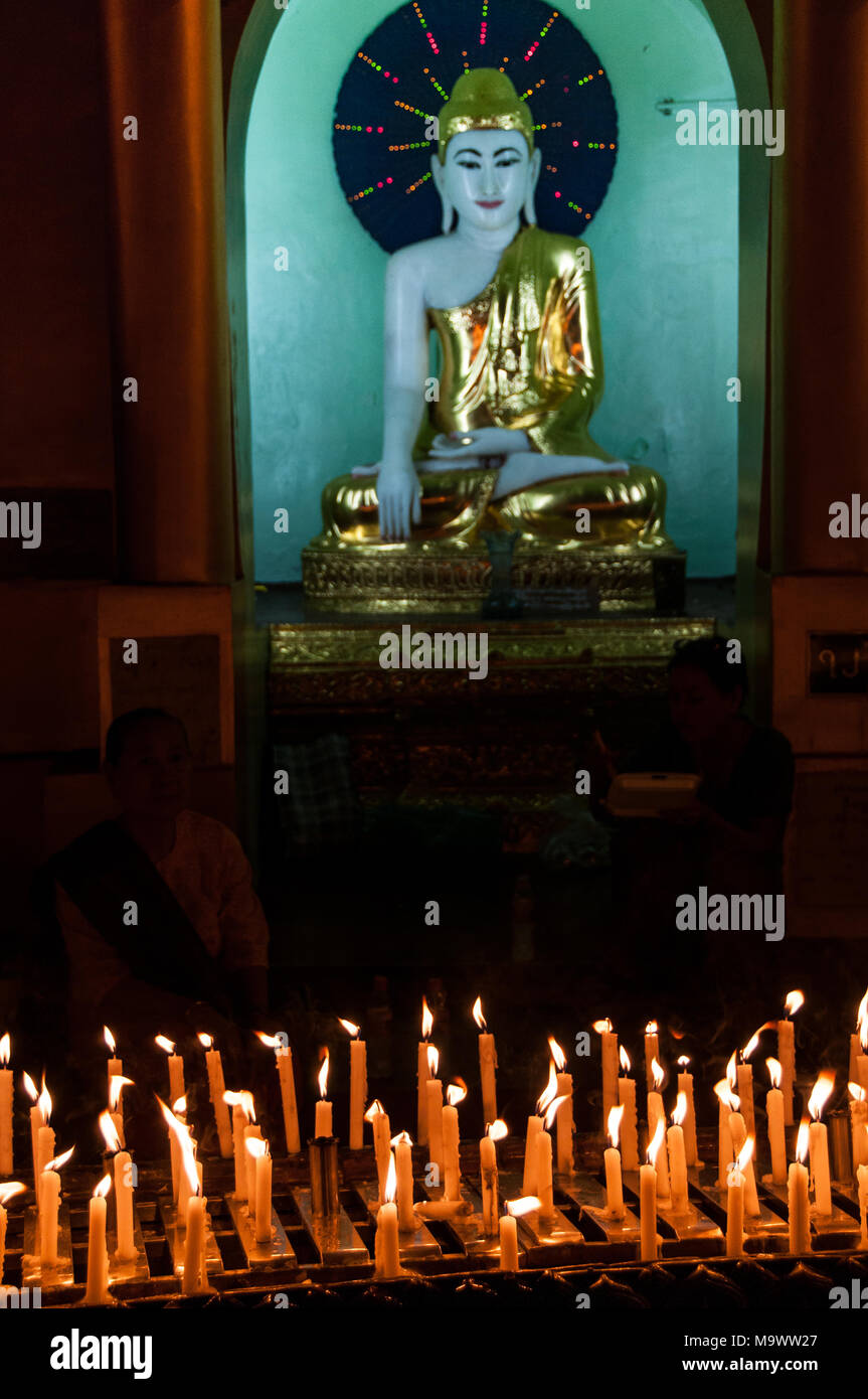 Buddha statue and candles in Shwedagon Pagode Stock Photo