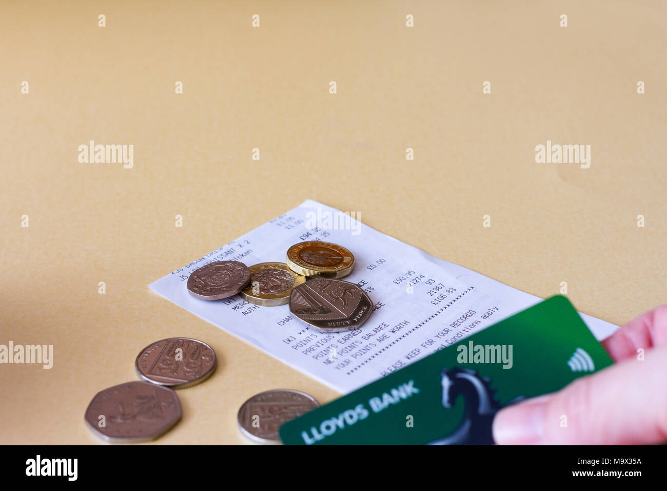 Shopping receipt with some cash coins & visa bank card, UK Stock Photo