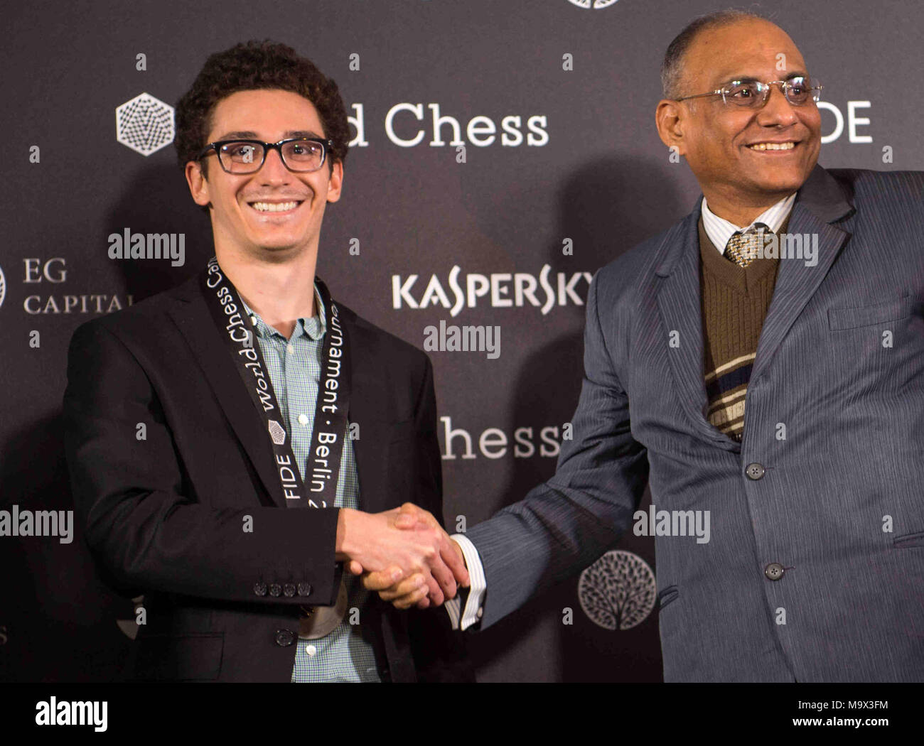 27 March 2018, Germany, Berlin: Vice-president of the International Chess Organisation FIDE, Damal Villivalam (R), congratulating American and Italian chess grand master, Fabiano Caruana (C), on the last day of the '